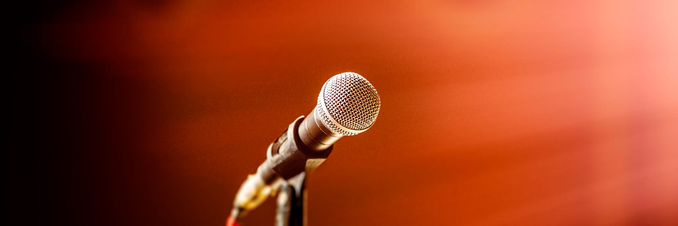 Concert microphone on blurred and stage lighting. Banner for design.